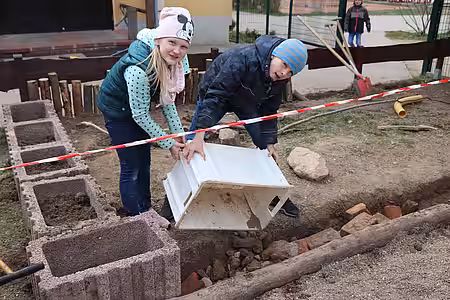 Die Kinder kippten die gesammelten Steine in die zuvor gegrabene Umfriedung als Untergrabschutz.